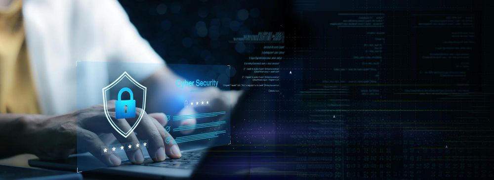 Hand on a laptop with a glowing security shield
